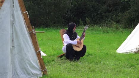 Recreación-Vikinga-Hombre-Vestido-De-época-Tocando-El-Laúd-En-Woods-Town-Waterford-Irlanda-En-Una-Brillante-Mañana-De-Verano