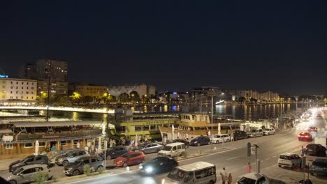 Hafen-Der-Stadt-Zadar-Mit-Straßenverkehr,-Fußgängern,-Brückenübergang-Und-Angedockten-Schiffen-In-Der-Nacht
