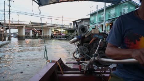 Guiando-Su-Bote-De-Madera-A-Lo-Largo-De-Las-Vías-Fluviales-Del-Mercado-Flotante-De-Amphawa,-El-Barquero-Lleva-A-Sus-Pasajeros-De-Turistas-En-Un-Recorrido-Nocturno-En-Samut-Songkhram,-Tailandia