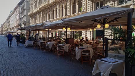 Staff-at-restaurant-in-Milan-serving-customers-under-canopies-outside