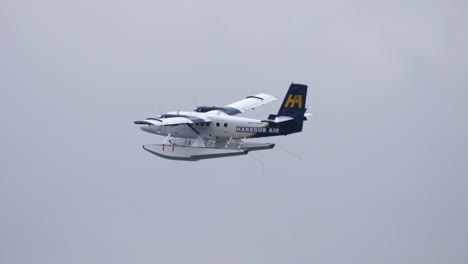 Harbour-Air-Twin-Otter-Float-Plane-Flying,-Grey-Sky-Backdrop-TRACK