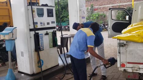 Trabajador-De-Surtidor-De-Gasolina-Llenando-Gasolina-En-El-Coche-Y-Conductor-Observando-La-Lectura-De-Gasolina-Por-Móvil