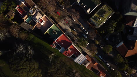 Top-down-aerial-view-over-a-street,-a-road-and-a-roof,-residential-area,-small-neighborhood