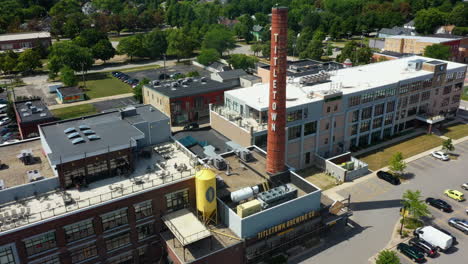 Aerial-view-tilting-toward-the-chimney-at-the-titletown,-in-sunny-Greenbay,-Wisconsin,-USA