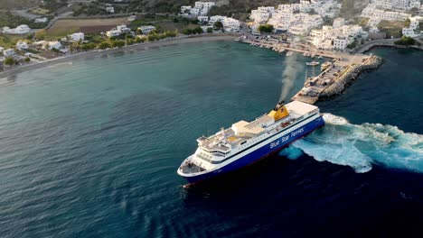 Aerial-View-Of-AEGIALI-Village-In-Greece-And-Big-Ferry-Ship-Turning-At-The-Sea