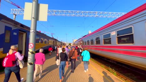 Los-Viajeros-Que-Llegan-A-La-Estación-Central-De-Riga-En-Una-Mañana-Soleada-Caminando-Entre-Vagones