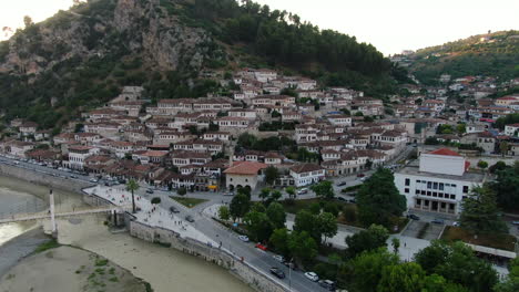 Berat,-city-of-Albania:-aerial-view-traveling-out-of-the-famous-houses-and-their-typical-Albanian-windows-and-the-Gorica-bridge-during-sunset