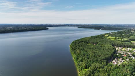 Aerial-view,-large-lake,-shores-covered-with-green-trees,-sunny-summer-day,-nature-of-Baltic-countries