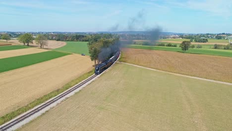 An-Aerial-View-of-a-Steam-Passenger-Train-Approaching-Around-a-Curve,-Blowing-Smoke-on-a-Sunny-Day