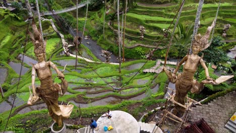 Aérea:-Estatuas-Gigantescas-De-Wi-Sri,-Diosas-Del-Arroz-En-Terrazas-De-Arroz-De-Alas-Harum-Que-Muestran-Habilidades-De-Construcción-Y-Arte-Religioso-Local.