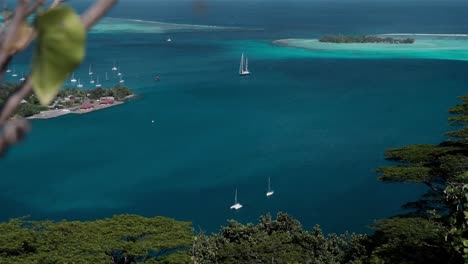 Stunning-scene-of-sailing-yachts-at-anchor-in-a-secluded-tropical-paradise-with-trees-and-reef-in-the-South-Pacific