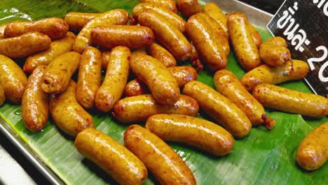 Close-Up-Panning-Shot-of-Freshly-Cooked-Northern-Sausages-Served-on-a-Banana-Leaf-at-a-Street-Stand