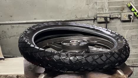 Mechanic-fixing-a-motorcycle-tire-in-his-workshop_Service-Man_Wheel