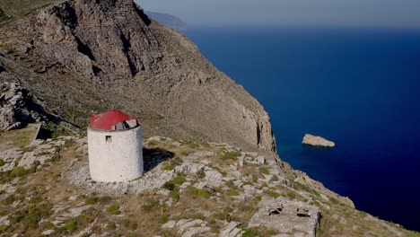 Rising-Up-Over-Chora-old-windmill-Aerial-On-Greek-Island-Of-Amorgos,-Massive-Blu-Sea-In-Background