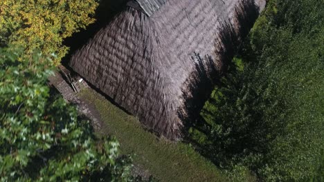 An-old-historic-rural-cottage-surrounded-by-trees-within-a-European-open-air-museum-during-the-summer-season