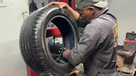 Mechanic-fixing-a-tire-in-his-work-shop