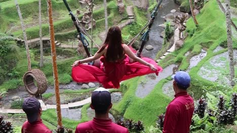 Frau-Im-Rosafarbenen,-Fließenden-Kleid-Schaukelt-In-Der-Kultigen-Tropischen-Outdoor-Schaukel-Auf-Bali