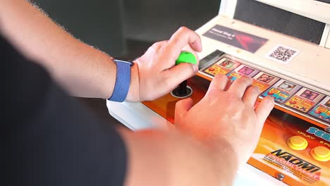 Gamer's-hands-playing-old-sega-arcade-game-with-joystick-and-buttons,-close-up-handheld-shot