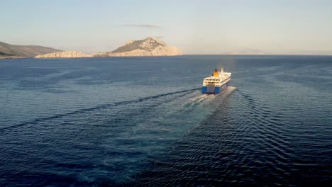Big-Ferry-Ship-Turning-At-The-Sea-And-Sails-To-The-Horizon,-Departs-From-AEGIALI-Village-In-Greece,-Aerial-View