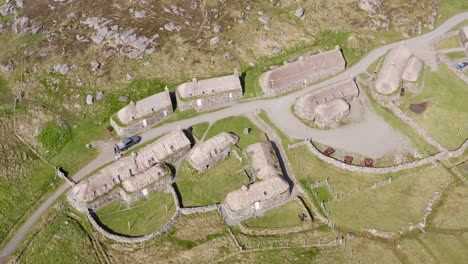 Dynamic-drone-shot-of-the-Gearrannan-Blackhouse-Village-on-the-Isle-of-Lewis,-part-of-the-Outer-Hebrides-of-Scotland