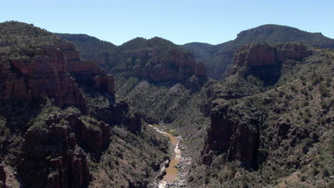 Drone-shot-flying-over-a-steep-desert-canyon,-sunny-day-in-Superior,-Arizona,-USA
