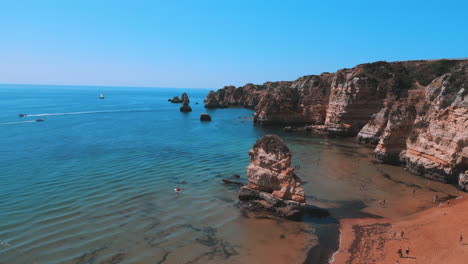 Felsige-Klippen-Und-Wunderschönes-Blaues-Meer-Im-Sommer-In-Praia-Dona-Ana-An-Der-Algarve-In-Portugal,-Drohnenaufnahme-Aus-Der-Luft