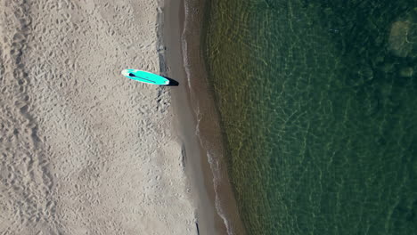 Sup-board-Paddleboard-on-Beautiful-sand-beach,-top-down-aerial-view