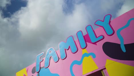 family-sign-in-blue-colour-and-pink-outlines-colourful-background-spinning-360-orbit-camera-movement-creative-childish-kids-area-designated-to-play-relax-leave-kids-to-be-cared-for-nursery-games