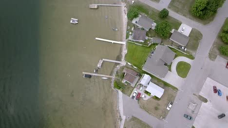 Dock-and-beach-of-Lake-Missaukee-in-Lake-City,-Michigan-with-drone-video-overhead-looking-down