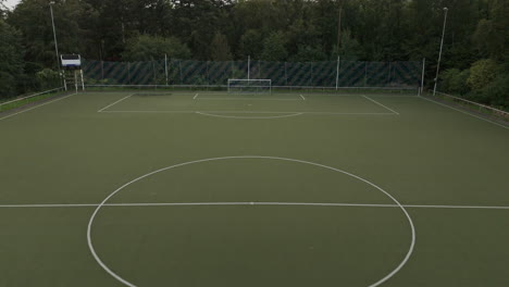 Volando-Sobre-El-Césped-De-Un-Campo-De-Fútbol-Verde-Con-Un-Dron,-Imágenes-Aéreas,-Campo-De-Fútbol,-Bosque-Alrededor