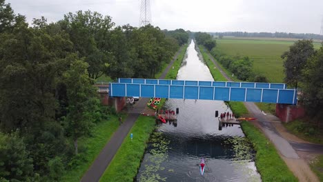 Menschen-Unter-Der-Brücke-Spielen-Einige-Herausforderungen-Auf-Dem-Sup-Board,-Während-Ein-Auto-über-Sie-Fährt