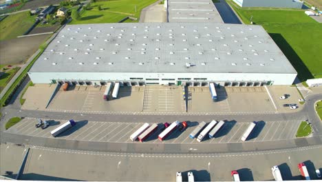 Aerial-view-of-distribution-center,-drone-photo-of-industrial-logistics-zone,new-super-modern-logistics-center-full-of-modern-technology-and-robotics,roof-solar-power-plant-for-green-energy-production