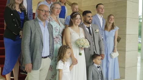 Family-picture-being-taken-with-groom-and-bride-on-the-stairs