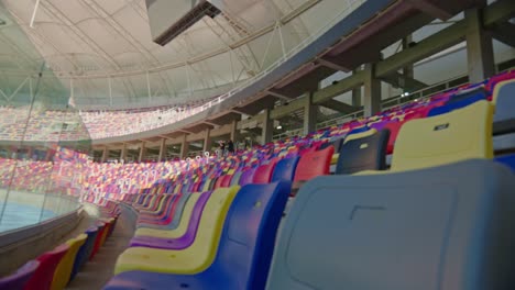 Bewegende-Aufnahme-Eines-Leeren-Profi-Fußballstadions,-In-Dem-Man-Die-Tribünen-In-Verschiedenen-Farben-Ohne-Publikum-Und-Eine-Riesige-Leinwand-Sehen-Kann