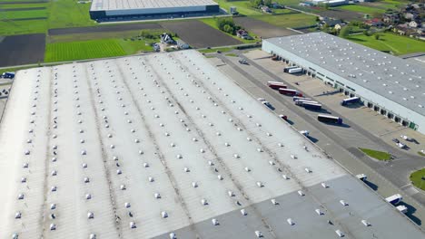 Vista-Aérea-Del-Centro-De-Distribución,-Fotografía-De-Drones-De-La-Zona-De-Logística-Industrial,-Nuevo-Centro-Logístico-Súper-Moderno-Lleno-De-Tecnología-Y-Robótica-Modernas,-Planta-De-Energía-Solar-En-El-Techo-Para-La-Producción-De-Energía-Verde