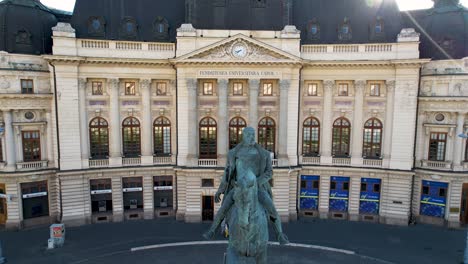 Rayos-De-Sol-Estallando-Sobre-La-Estatua-Del-Rey-Carol-I-Y-La-Biblioteca-De-La-Universidad-Central-En-Bucarest,-Rumania:-Una-Vista-Aérea