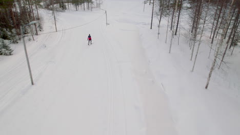 Skier-skiing-down-a-mountain-in-ski-tracks-in-the-middle-of-winter