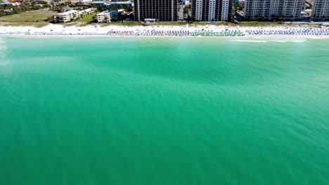 Destin-Florida-Beach-coastline-with-colorful-beach-chair,-umbrellas,-clouds-blue-sky,-Aerial-view-henderson-beach-state-park