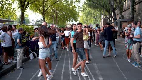 Dancing-Couples-at-Public-Paris-Summer-Festival:-Romantic-Atmosphere-by-the-Shores-of-River-Seine,-French-Culture,-Music,-and-Celebration