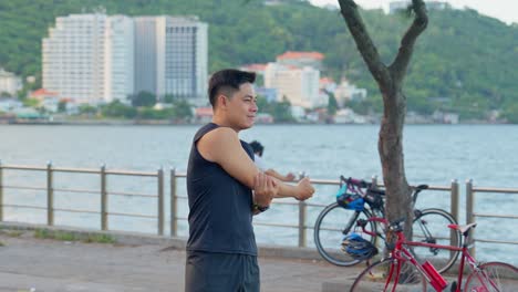 Close-up-of-a-man-stretching-the-muscles-to-prepare-for-a-morning-workout-at-the-beach