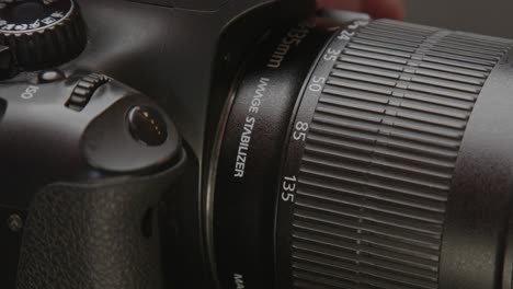Hand-removing-lens-from-digital-DSLR-photo-camera
