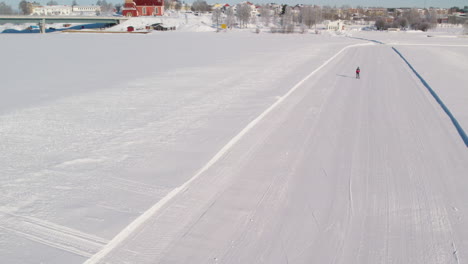 Skier-skiing-on-a-frozen-river-next-to-the-town-of-Kalix-in-northern-Sweden