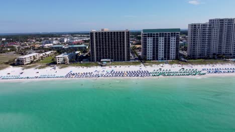 Destin-Florida-Aerial-view-of-Sundestin-Beach-Resort,-Destin,-Florida,-United-States-and-coastline-with-colorful-beach-chair,-umbrellas,-clouds-blue-sky,-Aerial-of-Gulf-of-mexico