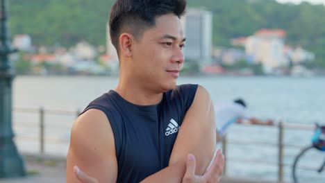 Close-up-of-a-man-stretching-the-muscles-to-prepare-for-a-morning-workout-at-the-beach