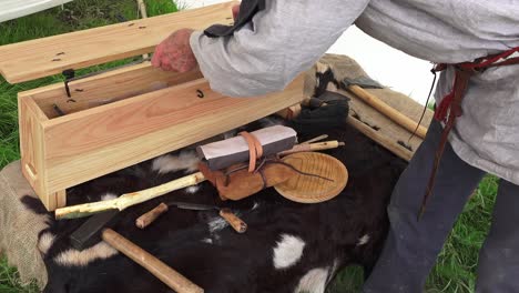 Viking-re-enactment-man-in-period-clothes-removes-from-toolbox-ancient-implements-used-for-woodworking-by-the-Vikings-Waterford-Ireland