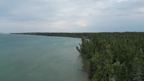 A-moving-aerial-drone-shot-of-Clearwater-Lake-from-Sunset-Beach-on-the-outskirts-of-The-Pas-area-during-the-Summer-of-2023-during-a-cloudy-day