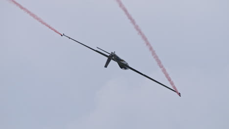 Swift-s-1-glider-doing-tricks-in-sky-with-mountains-in-background,-handheld-view