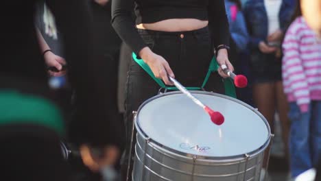 Slow-motion,-tight-shot-of-a-female-group-of-"murga"-drummers-performing-in-the-street