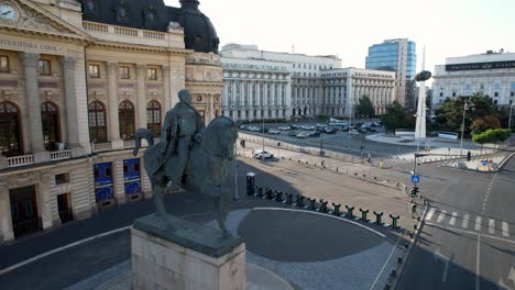 Vista-Aérea-Giratoria-De-La-Estatua-Del-Rey-Carol-I-De-Rumania-Frente-A-La-Biblioteca-De-La-Universidad-Central-En-La-Avenida-Calea-Victoriei