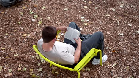 Hombre-Leyendo-Un-Libro-En-El-Parque-De-París-Durante-El-Verano:-Momentos-Tranquilos,-La-Literatura-Se-Encuentra-Con-La-Naturaleza,-Una-Relajante-Experiencia-Urbana-Al-Aire-Libre-En-Francia